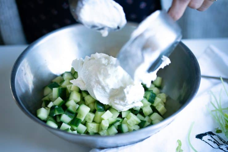 Yogurt and cucumbers being mixed together