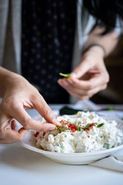 Adding mint leaves to the raita