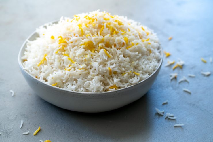 A bowl of basmati rice with some yellow saffron rice for color