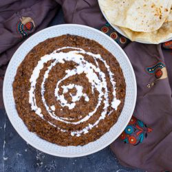 A bowl of dal makhani served with roti