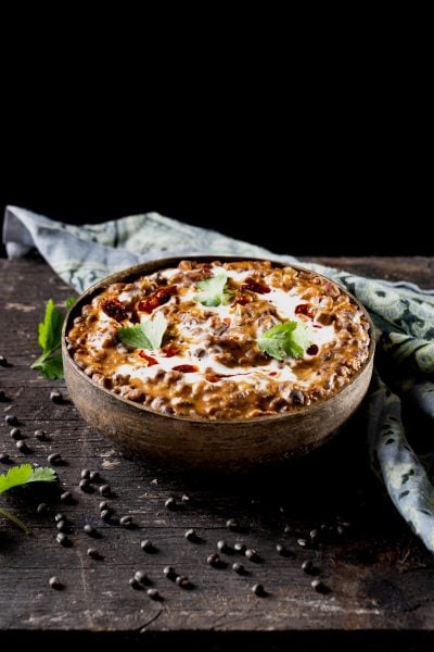 Bowl of dal makhani with a black background