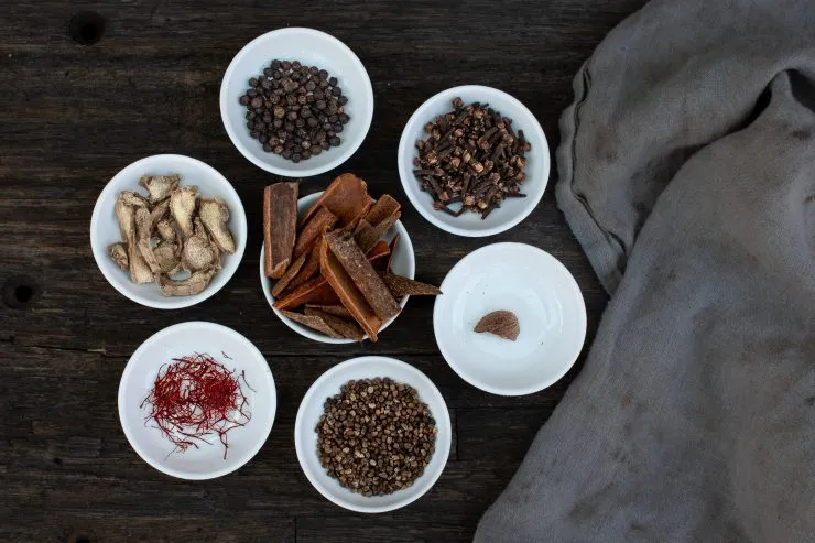 Spices of chai masala: black pepper, cloves, nutmeg, cardamom, saffron, ginger, cinnamon