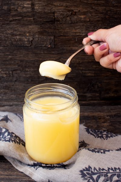 Spooning out ghee from a jar