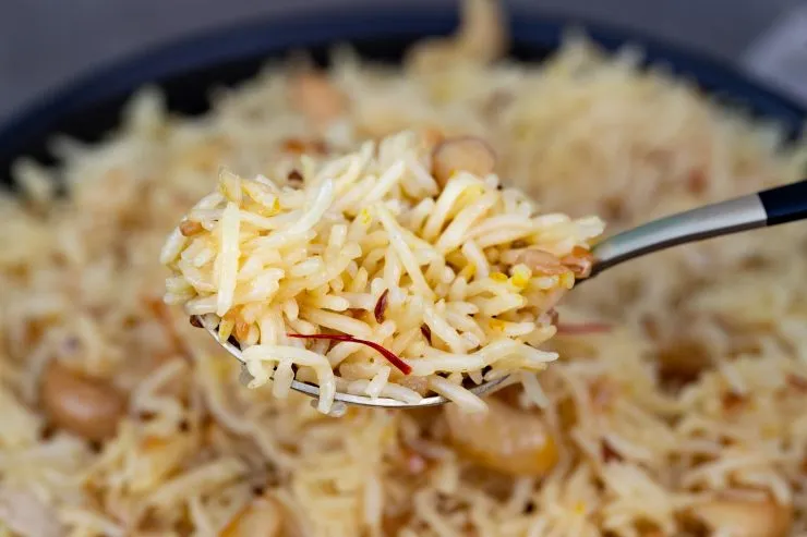 A spoon holding some onion rice pilaf