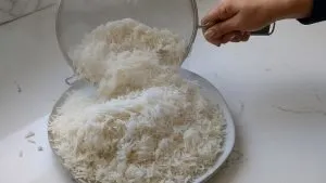 Putting the rice on a plate after straining out the water