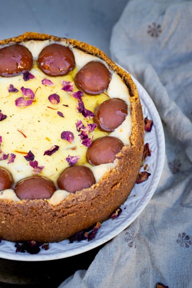 A whole gulab jamun cheesecake on a plate