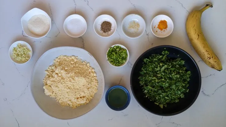 Methi na gota ingredients: besan, fenugreek leaves, banana, rava, salt, turmeric, black pepper, green chilies, garlic, hing