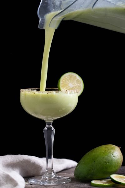 Pouring a raw mango margarita