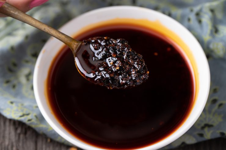 Taking a spoonful of chili oil from a bowl