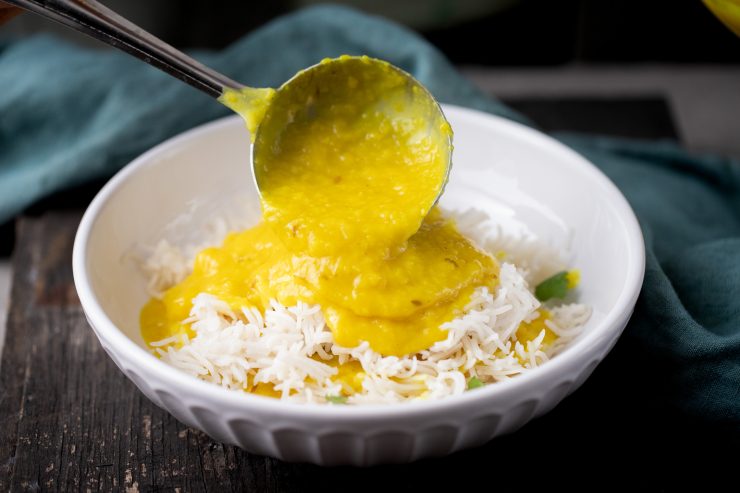 Pouring dal over the rice to serve