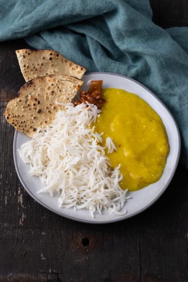 A plate of dal chawal with some papdi