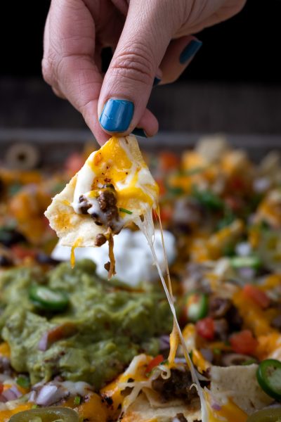 Holding a chip from the dal makhani nachos