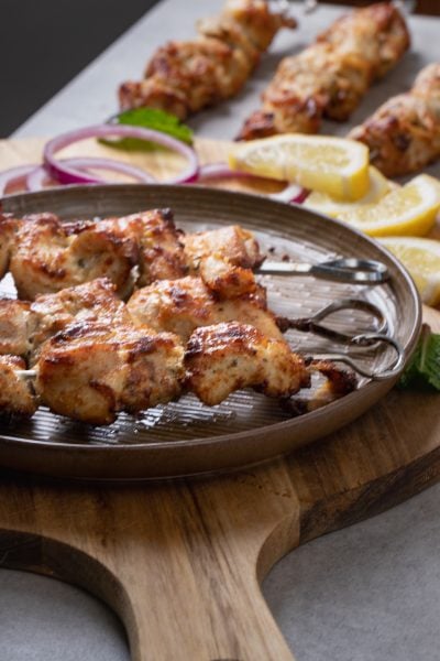 Serve malai chicken kababs with onions and lemon slices