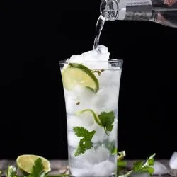 Pouring tonic into the cilantro gin and tonic
