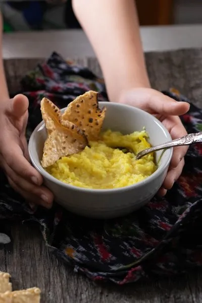 Child's hands holding a bowl of ghee
